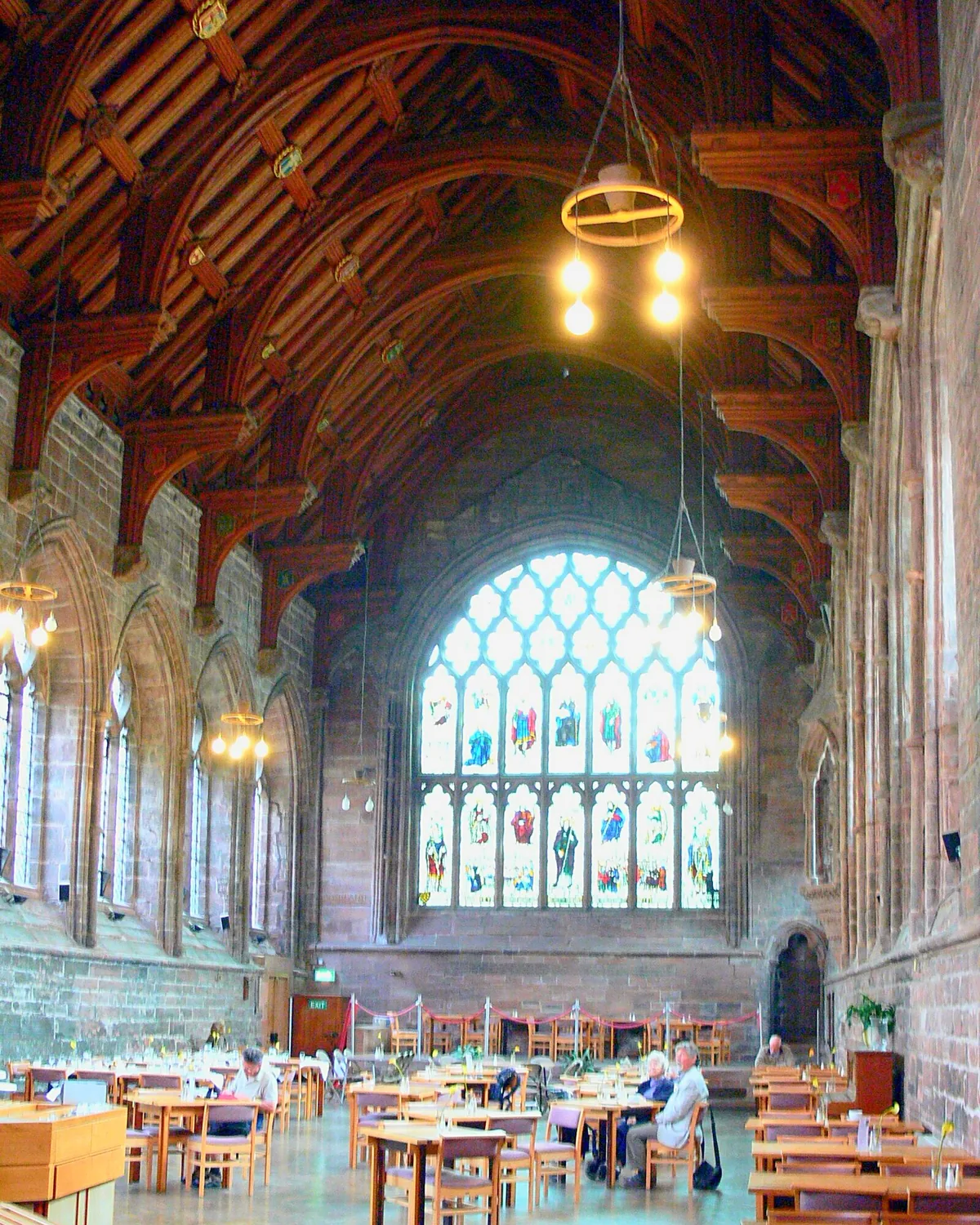 The Refectory at Chester Cathedral, set with café tables beneath its great window and timber roof