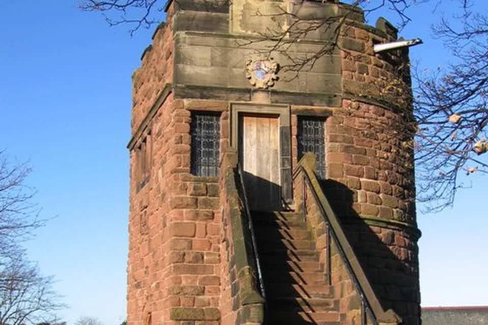 King Charles Tower, a square red sandstone tower on the city walls, with steps up its side and the wall walk beside it