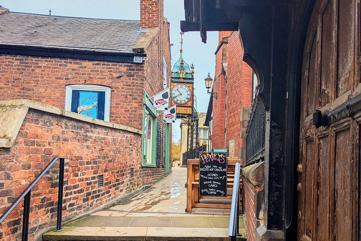 Worn steps up a narrow lane on the city walls, with the Eastgate Clock just visible ahead