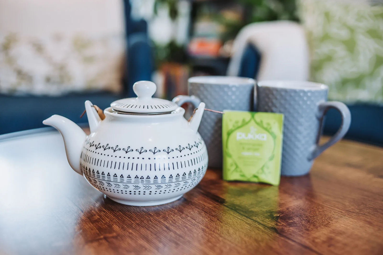 A teapot and two mugs on the coffee table in the living room