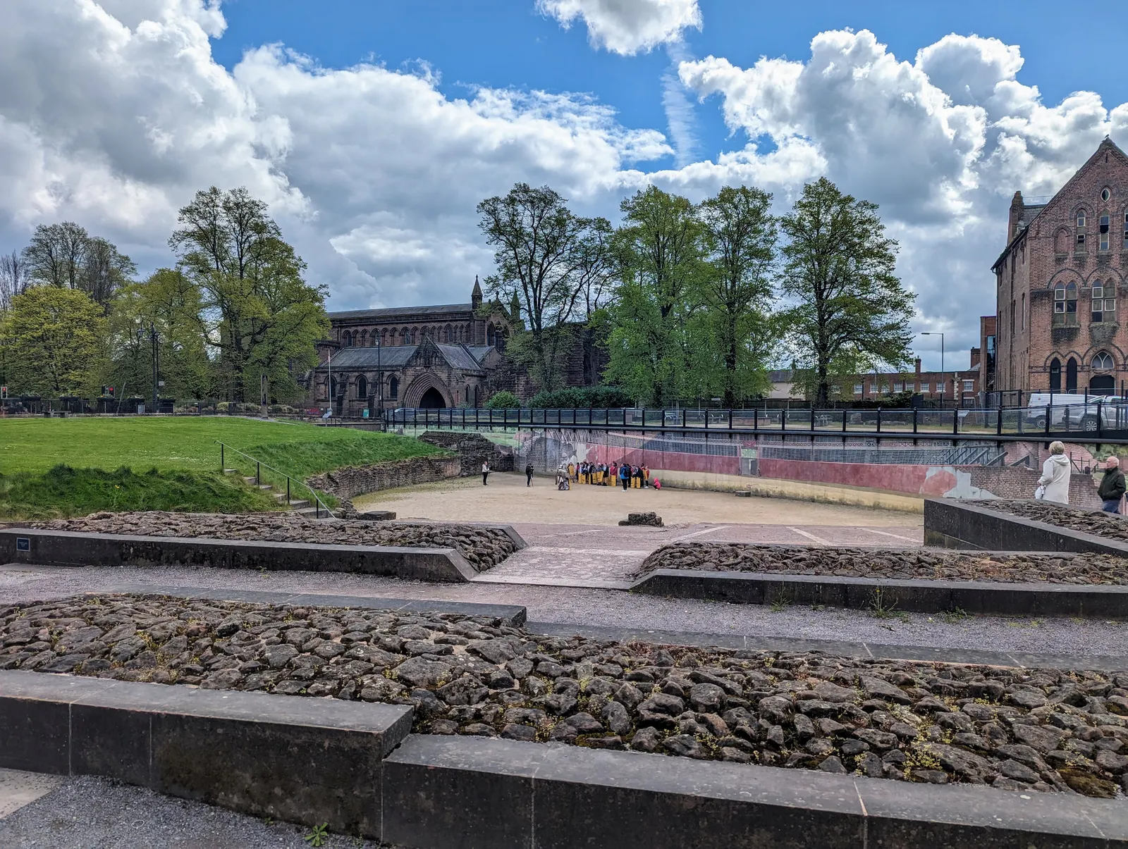 Chester's Roman amphitheatre with autumn trees and St John's church behind