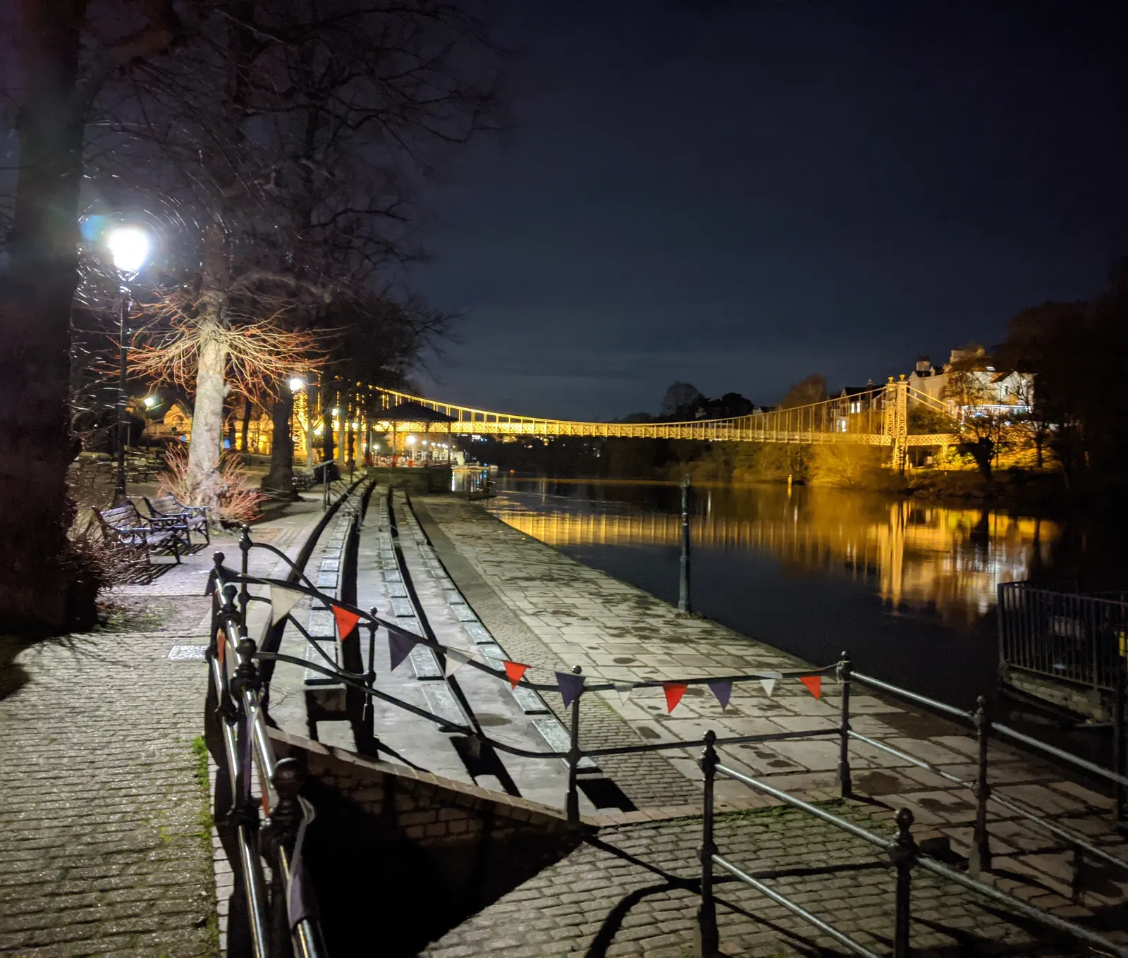 Queen's Park suspension bridge reflected in the River Dee at night
