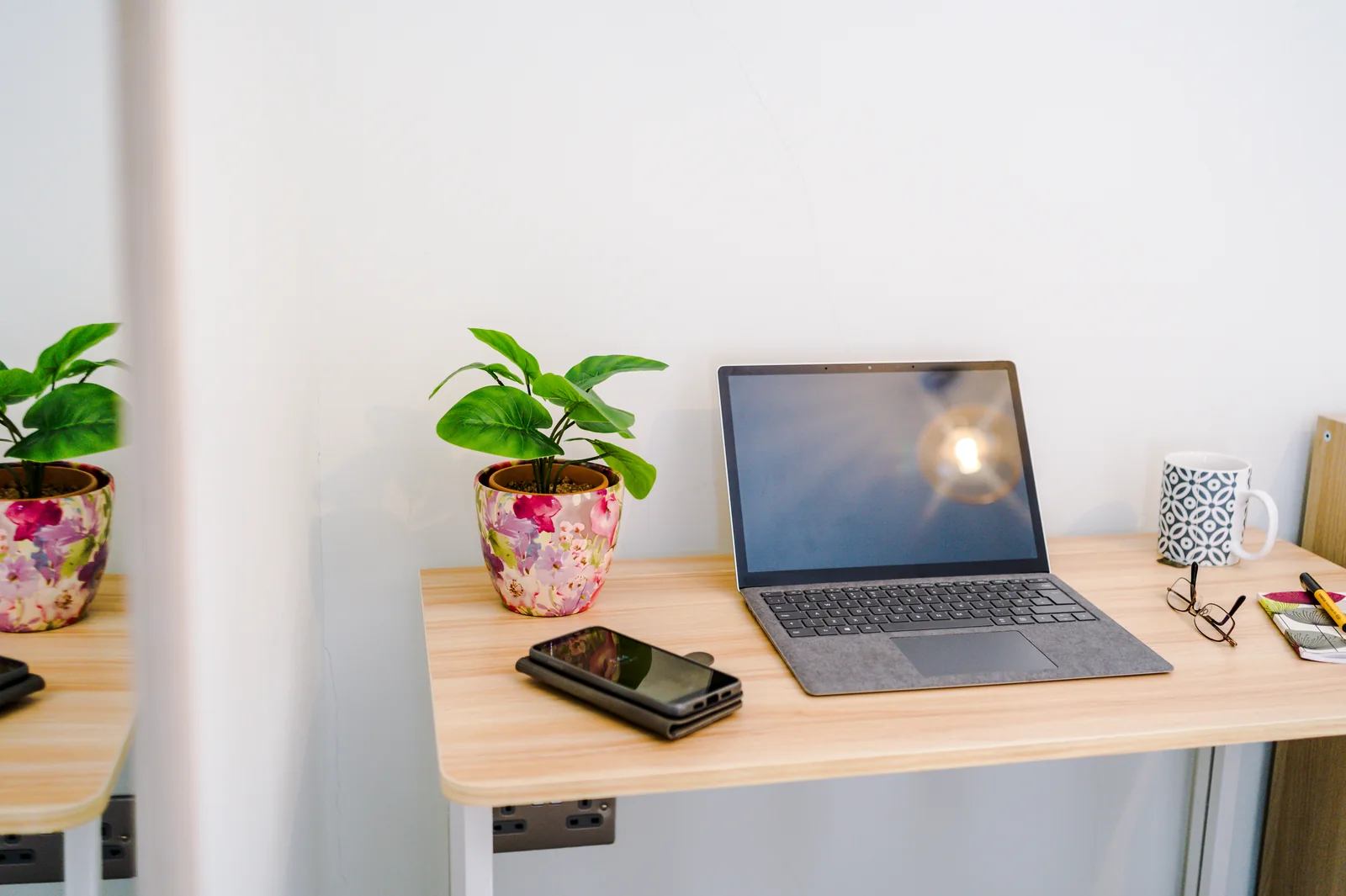 Standing desk with a laptop and plant set up for working in the main bedroom