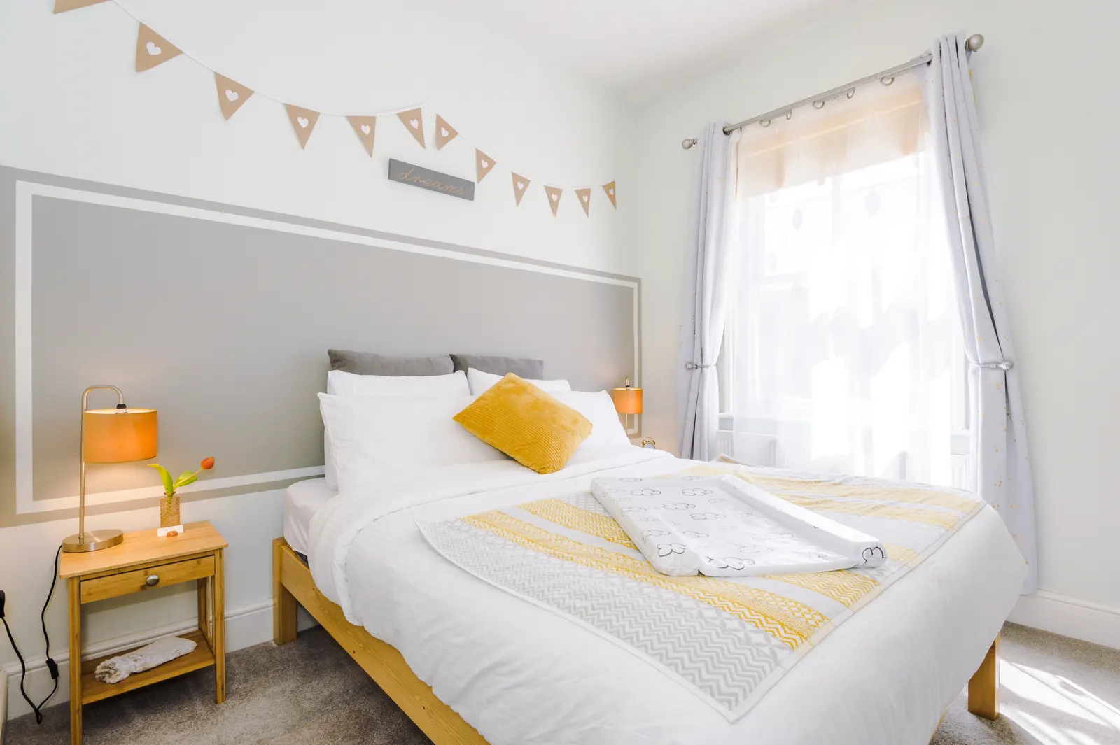 Double bedroom with soft daylight from the curtained window