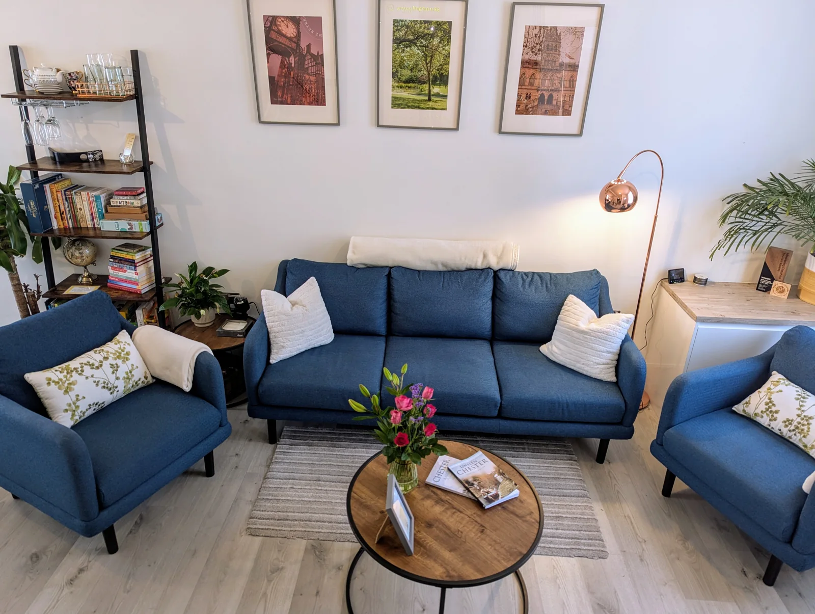 Lounge with blue sofa, armchair and fresh flowers on the coffee table