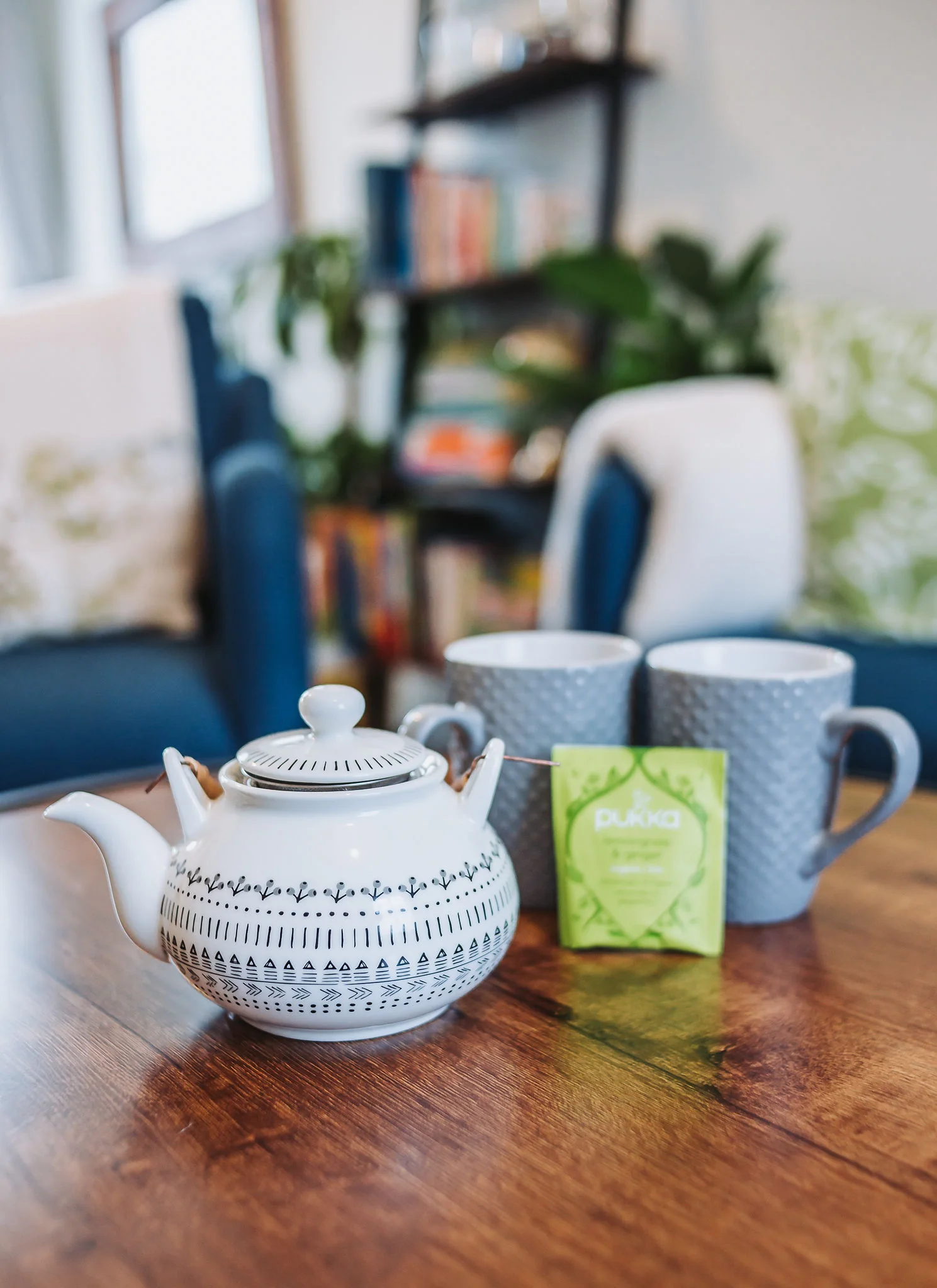Teapot, two mugs and herbal tea ready on the lounge table