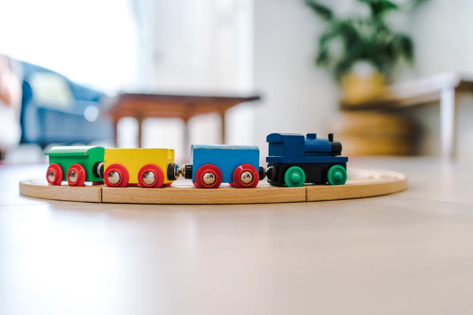 Wooden toy train set laid out on the living room floor